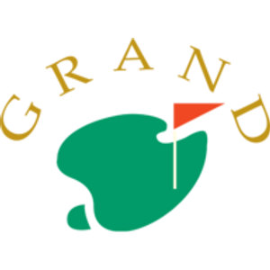 The Grand Golf Club logo: The word GRAND in gold serif capitals arched over a green kidney-shaped putting green with a white flagstick flying a small orange-red triangular pennant.