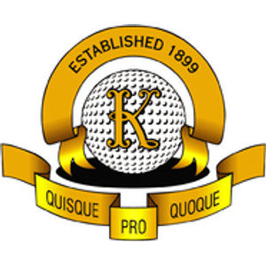 Keysborough Golf Course logo: A gold arched banner lettered ESTABLISHED 1899 in black capitals curving above a white dimpled golf ball carrying an ornate gold letter K and resting on a black base, over a gold ribbon reading QUISQUE at the left and QUOQUE at the right in black, with a small gold tab lettered PRO dipping below the centre.