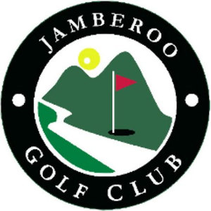 Jamberoo Golf Club logo: A black circular badge lettered JAMBEROO in white capitals across the top and GOLF CLUB across the bottom with a plain white dot at each side, enclosing a white disc showing two dark green hills, a yellow sun, and a red pennant flag on a white pin beside a black hole, above a bright green fairway curving down to the front left.