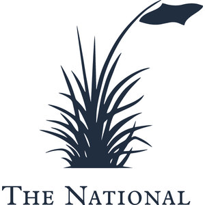 The National Golf Club logo: A clump of navy dune grass with a long curved flagpole arcing up to the right carrying a navy pennant, above THE NATIONAL in navy serif small capitals.