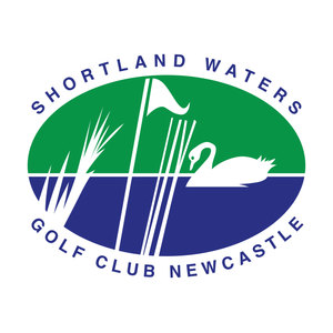 Shortland Waters Golf Club logo: An oval badge split green above and navy below, with a white swan facing left with its head lowered and its tail feathers pointed, floating on the line where the two halves meet among tall white reeds beside a white flag on a long white flagstick, and SHORTLAND WATERS arcing above the oval and GOLF CLUB NEWCASTLE arcing below it in navy capitals.