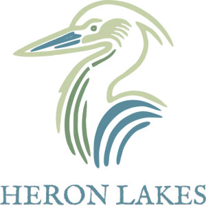 Heron Lakes Great Blue logo: A heron's head and curved neck drawn in flowing sage-green and slate-blue brush strokes, above the words 'HERON LAKES' in slate-blue capitals.