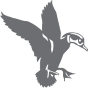 Woodcreek logo: A solid slate-gray silhouette of a wood duck landing, wings raised high above its back and orange-free feet outstretched forward, facing right, with white cut-out lines marking the swept-back head crest, eye, and bill.